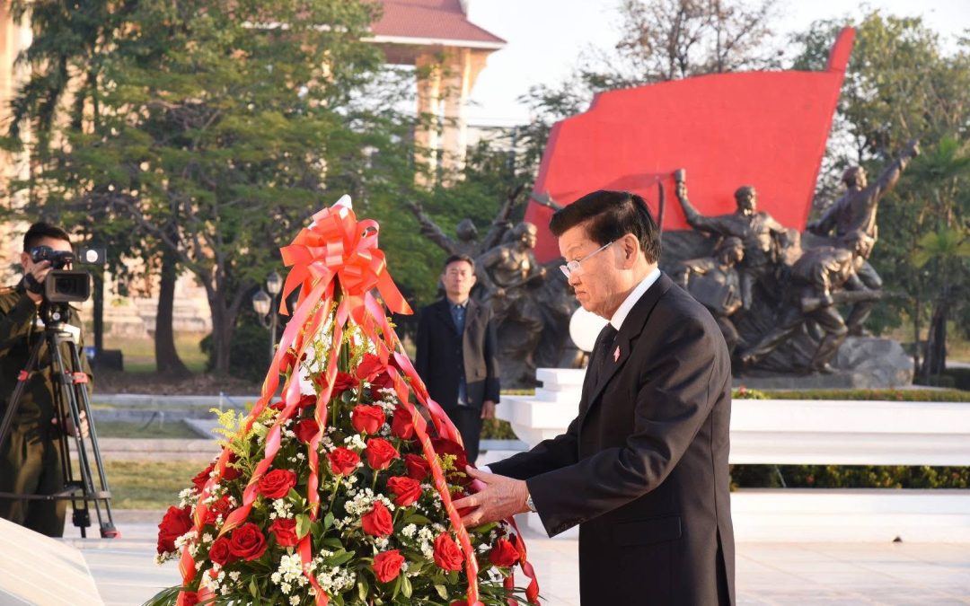 ຄະນະບໍລິຫານງານສູນກາງພັກ ສະໄໝທີ XII ວາງກະຕ່າດອກໄມ້ຕໍ່ໜ້າຮູບປັ້ນຫຼ່ໍປະທານ ໄກສອນ ພົມວິຫານ